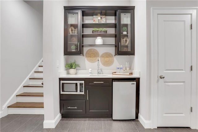 4550 Lois St SE, Smyrna, GA 30080 - indoor wet bar with stainless steel microwave, fridge, baseboards, and stairs