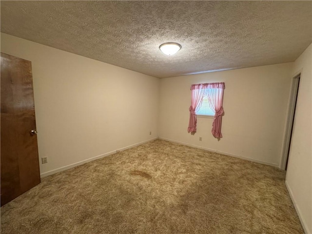 unfurnished room featuring baseboards, a textured ceiling, and carpet