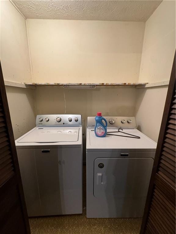 laundry room with washer and dryer, a textured ceiling, and laundry area