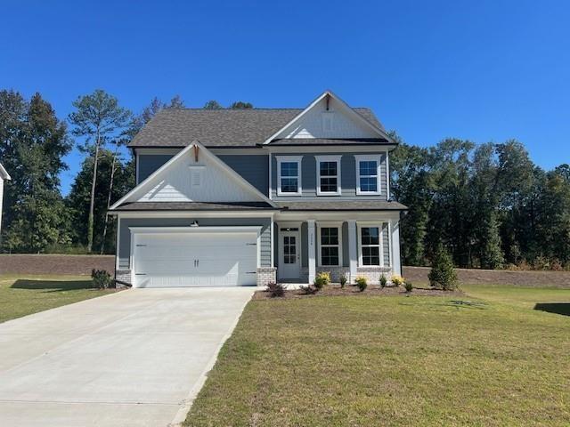 view of front of property with a garage, driveway, and a front yard