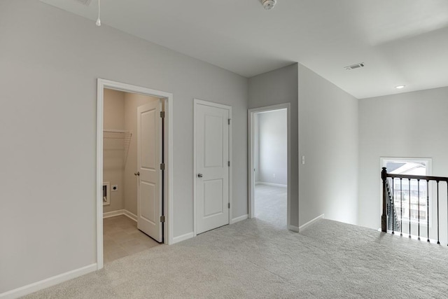 carpeted empty room with baseboards and visible vents