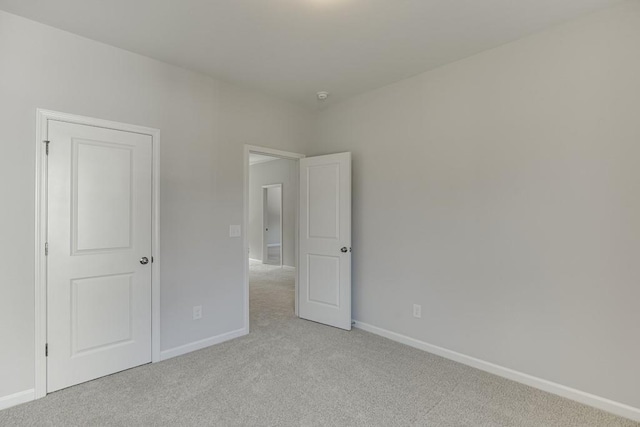 interior space with baseboards and light colored carpet