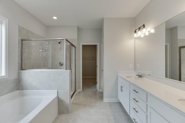 full bath featuring a stall shower, a sink, a bath, and a walk in closet