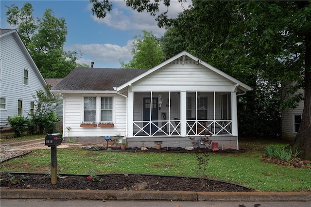 view of front facade with a sunroom and a front yard