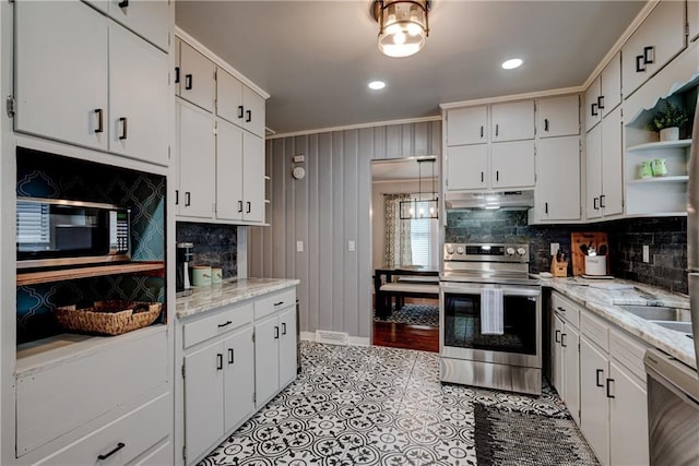 kitchen featuring light stone countertops, stainless steel appliances, backsplash, crown molding, and white cabinets