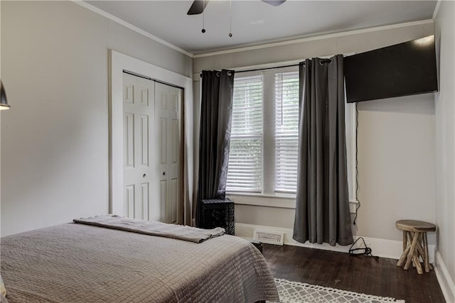 bedroom with dark hardwood / wood-style flooring, a closet, multiple windows, and ceiling fan