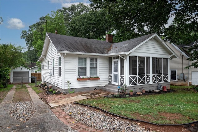 view of front of home featuring a front yard, a garage, and an outdoor structure