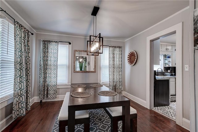 dining area featuring sink, ornamental molding, dark wood-type flooring, and an inviting chandelier