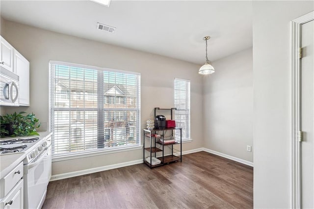 dining area featuring a wealth of natural light, visible vents, baseboards, and dark wood-style floors