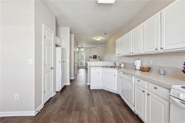 kitchen featuring white cabinets, a peninsula, white appliances, a ceiling fan, and dark wood-type flooring