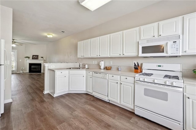 kitchen with open floor plan, white appliances, dark wood-style flooring, white cabinets, and a peninsula
