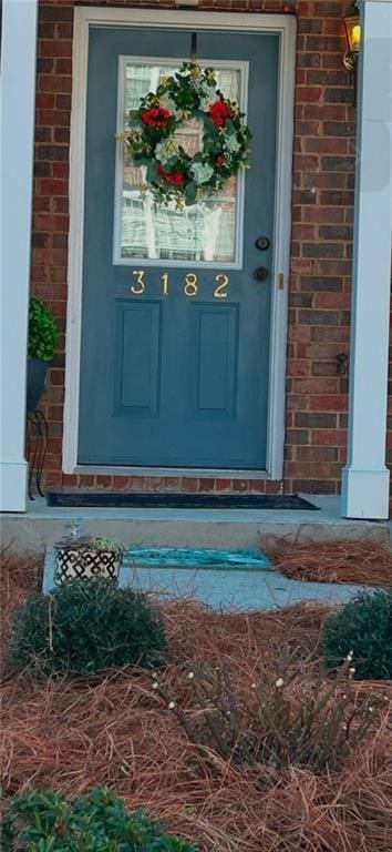 view of exterior entry with brick siding
