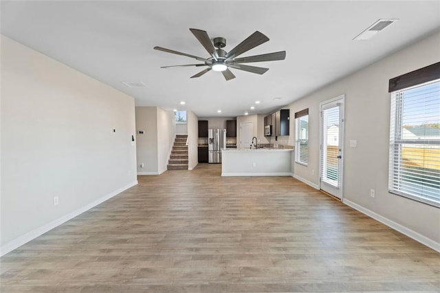 165 Twin Lakes Dr, Covington, GA 30016 - unfurnished living room featuring plenty of natural light, visible vents, light wood-style flooring, and ceiling fan