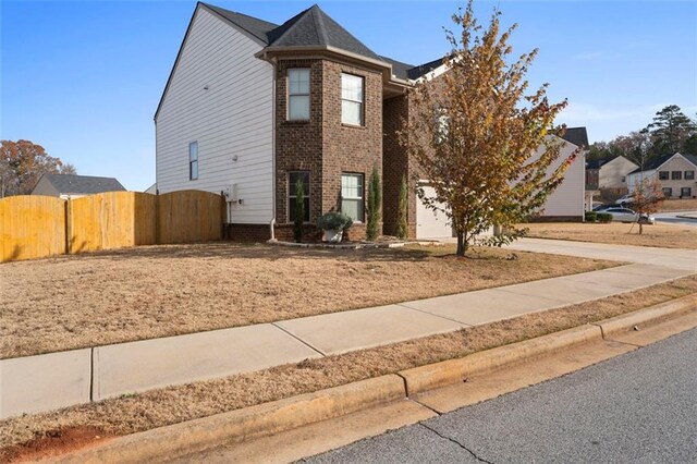 165 Twin Lakes Dr, Covington, GA 30016 - view of front facade featuring a gate, concrete driveway, fence, a garage, and brick siding