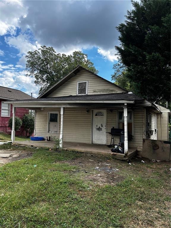 bungalow with a front lawn and covered porch