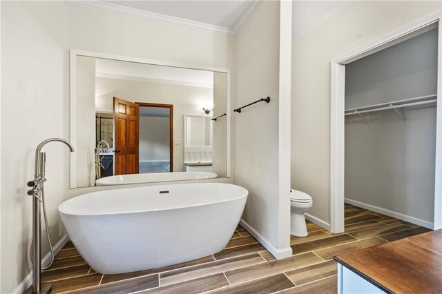 kitchen featuring a sink, a peninsula, light wood finished floors, ornamental molding, and stainless steel appliances