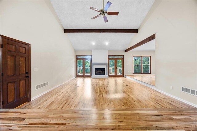 unfurnished living room featuring visible vents, wood finished floors, and a healthy amount of sunlight