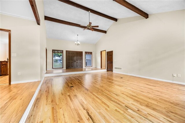 unfurnished living room with visible vents, beam ceiling, baseboards, light wood-type flooring, and ceiling fan with notable chandelier
