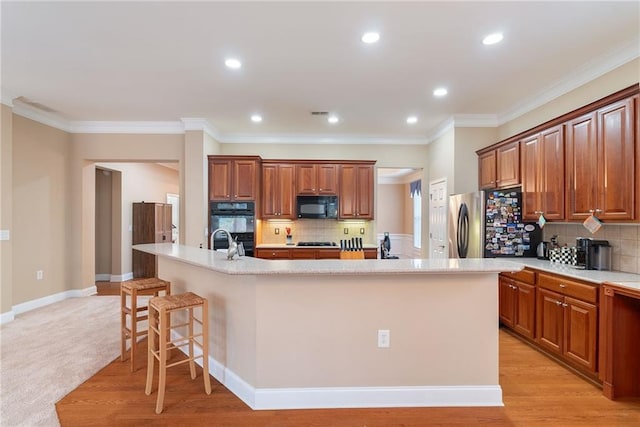 6355 Marlow Dr, Cumming, GA 30041 - kitchen featuring black appliances, a spacious island, tasteful backsplash, and a breakfast bar area