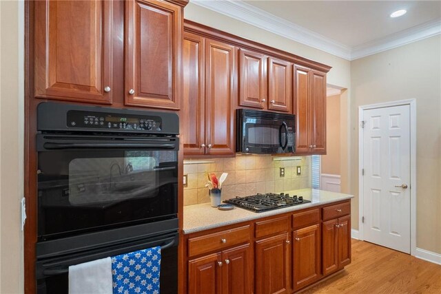 6355 Marlow Dr, Cumming, GA 30041 - kitchen featuring tasteful backsplash, light wood-type flooring, crown molding, light countertops, and black appliances
