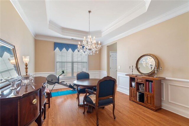 6355 Marlow Dr, Cumming, GA 30041 - dining room with a tray ceiling, light wood-style flooring, a wainscoted wall, and a notable chandelier