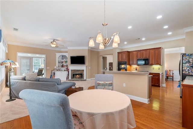 6355 Marlow Dr, Cumming, GA 30041 - dining area featuring ornamental molding, light wood finished floors, and ceiling fan with notable chandelier