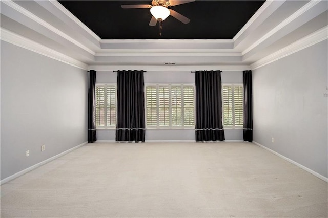 carpeted spare room with ceiling fan, a raised ceiling, and ornamental molding