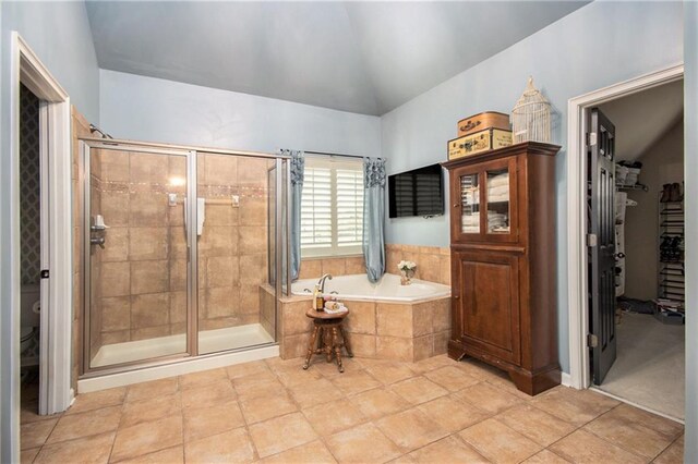 bathroom with toilet, tile patterned floors, vaulted ceiling, and plus walk in shower