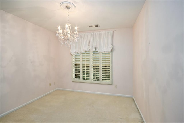 empty room featuring light carpet and a chandelier