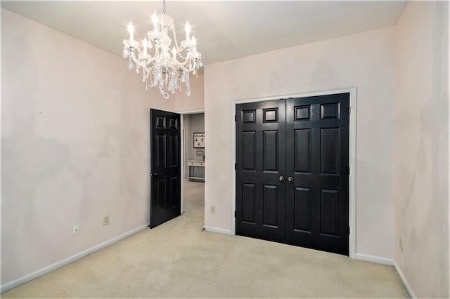 unfurnished bedroom featuring a closet, light carpet, and a chandelier