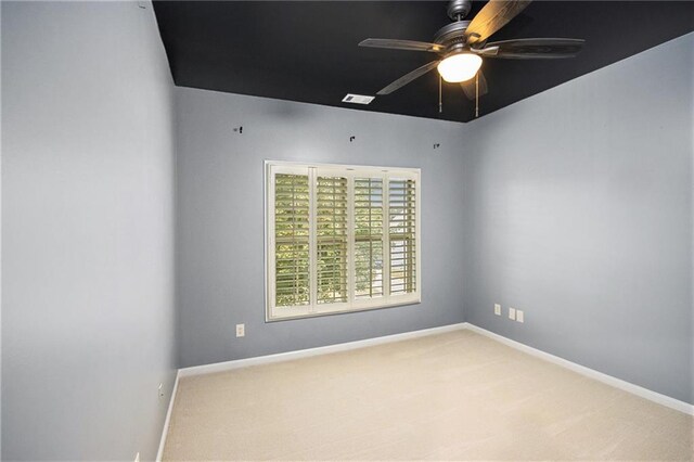 carpeted spare room featuring ceiling fan