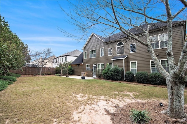 back of house with a patio area and a lawn