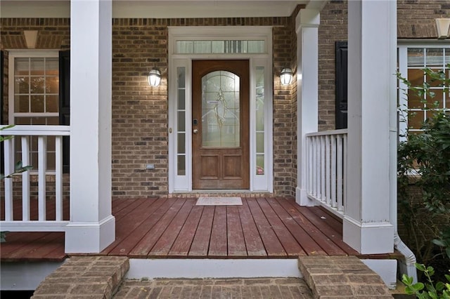 view of exterior entry featuring covered porch