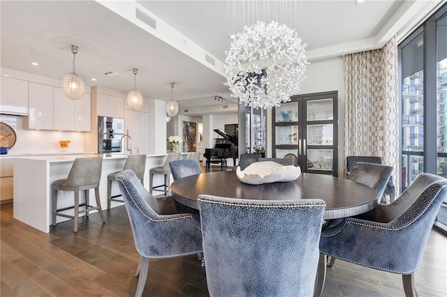 dining room featuring a notable chandelier, visible vents, and dark wood-style flooring