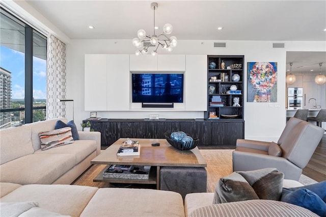 living area featuring recessed lighting, wood finished floors, visible vents, and a notable chandelier