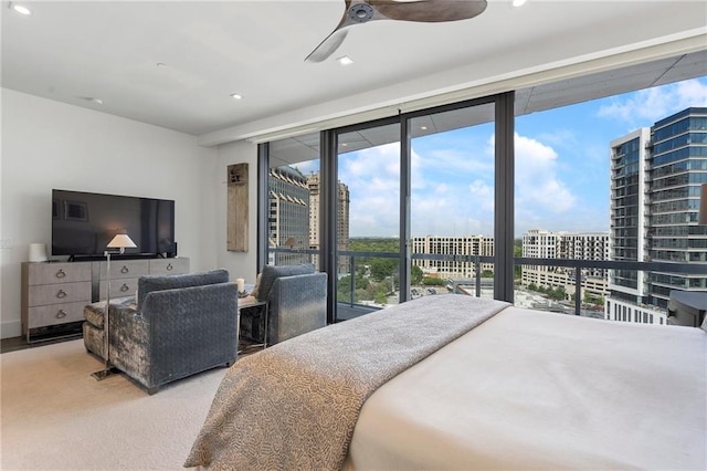 carpeted bedroom with a ceiling fan, access to outside, a city view, and recessed lighting