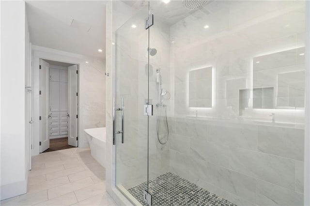 full bathroom with a freestanding bath and a shower stall