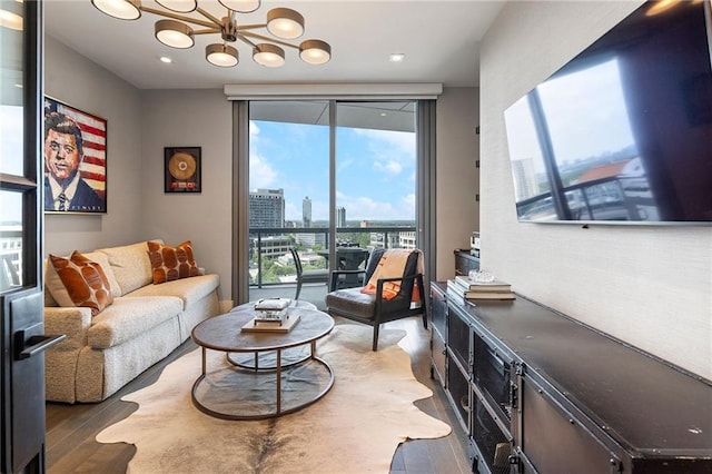 living area featuring a wall of windows, a notable chandelier, and light wood-style flooring