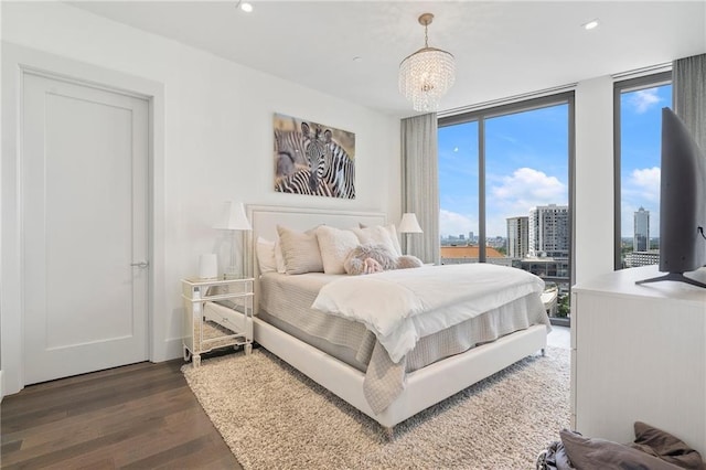 bedroom featuring a wall of windows, dark wood-type flooring, and recessed lighting