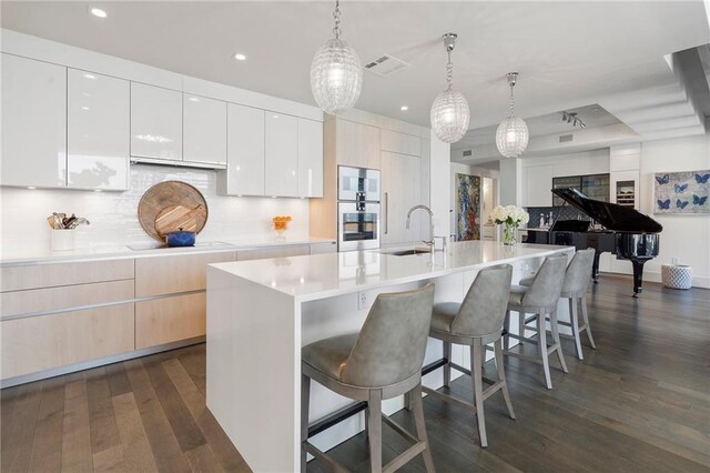 kitchen with dark wood-type flooring, visible vents, decorative backsplash, and modern cabinets