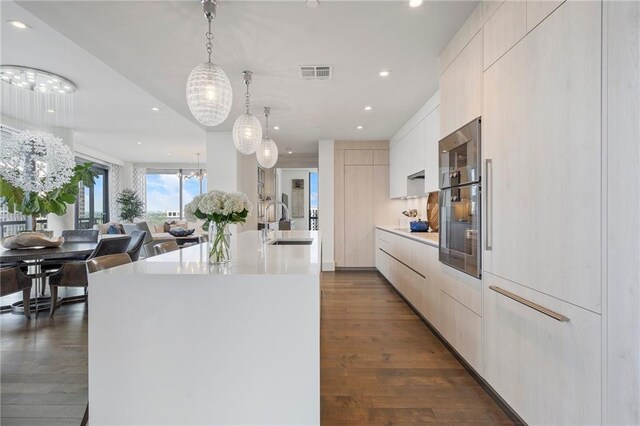 kitchen featuring visible vents, modern cabinets, a sink, an inviting chandelier, and light countertops