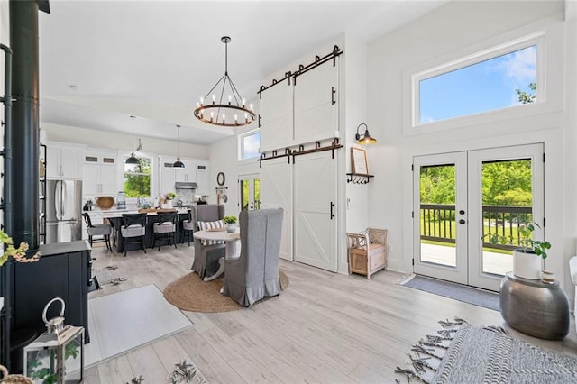 4791 Talona Rd, Talking Rock, GA 30175 - foyer with a barn door, french doors, light wood-style floors, a chandelier, and a towering ceiling
