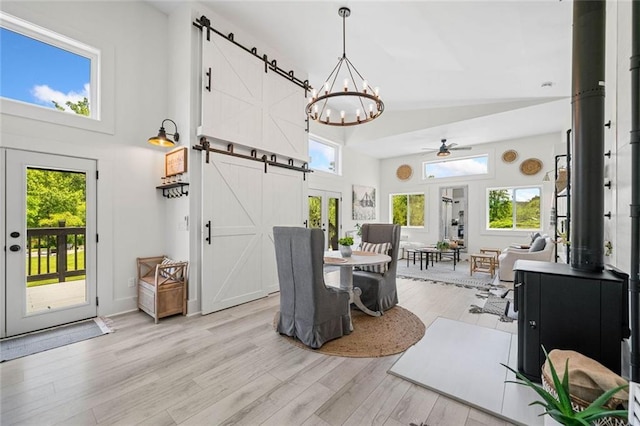 4791 Talona Rd, Talking Rock, GA 30175 - dining area featuring a towering ceiling, a barn door, light wood finished floors, a chandelier, and a ceiling fan