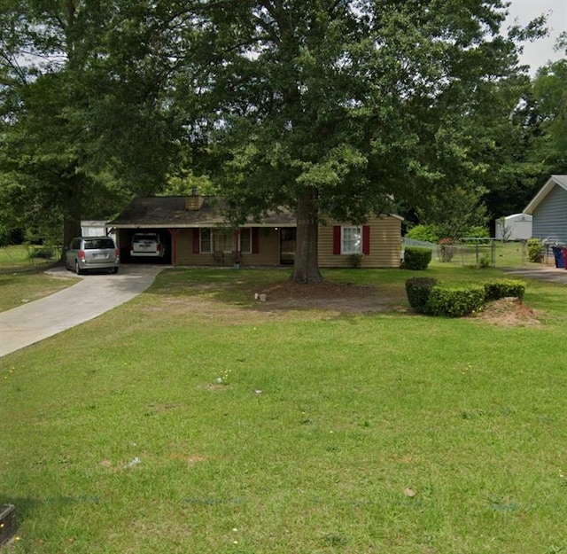 ranch-style home featuring concrete driveway, an attached carport, and a front yard