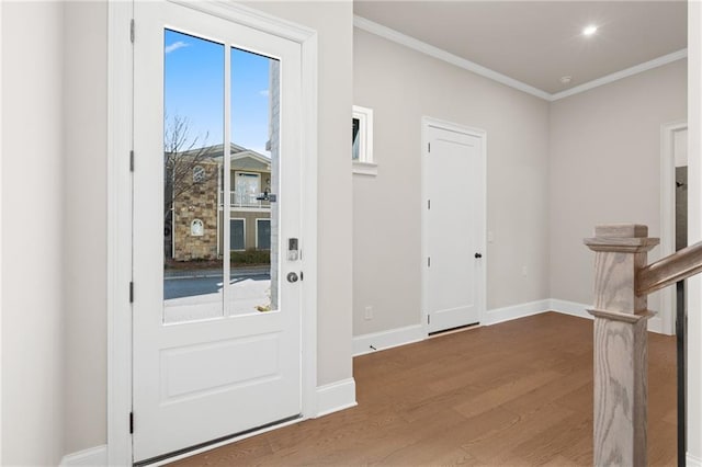 entrance foyer with wood-type flooring, a healthy amount of sunlight, and crown molding