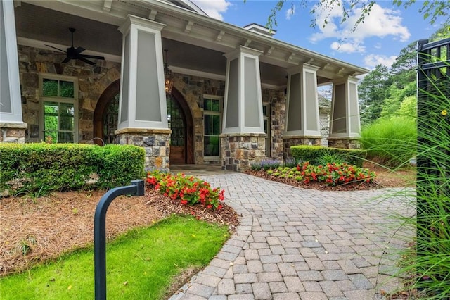 doorway to property featuring a porch and ceiling fan