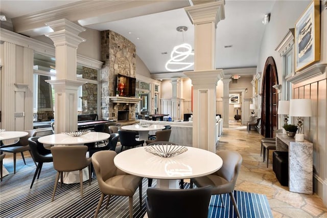 dining area with vaulted ceiling and a fireplace