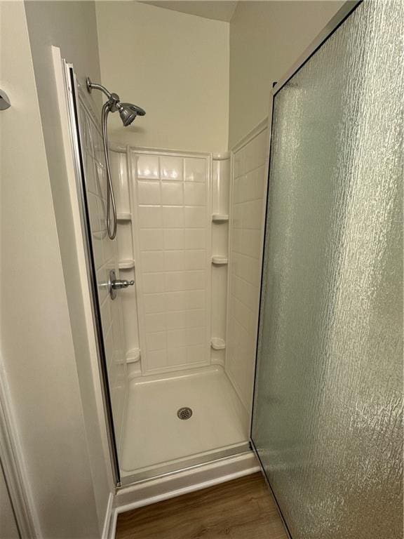 full bath with a stall shower and wood finished floors