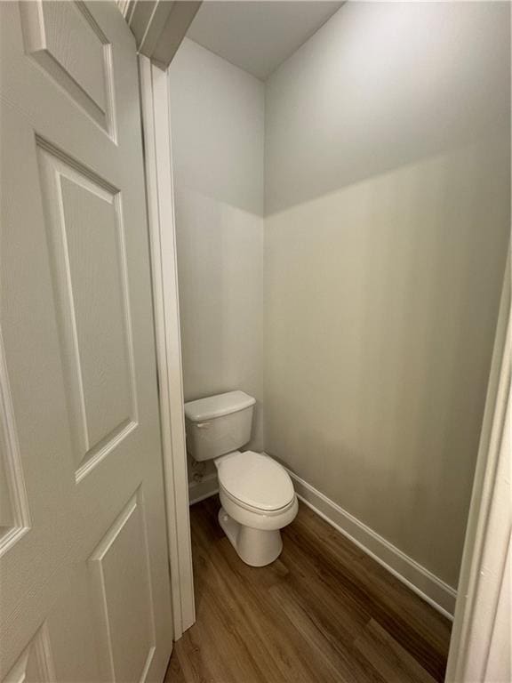 bathroom featuring toilet, baseboards, and wood finished floors