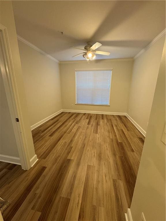 unfurnished room with baseboards, crown molding, and wood finished floors